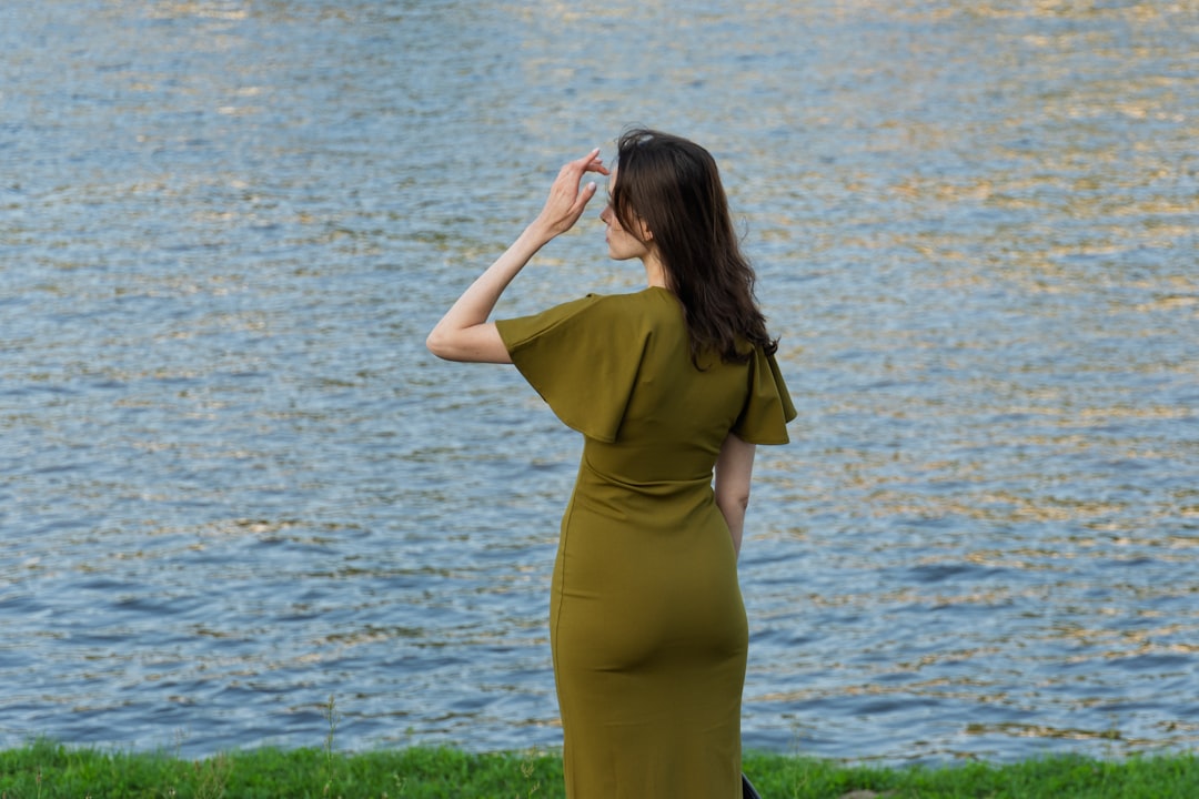 Woman in green dress looking at the water