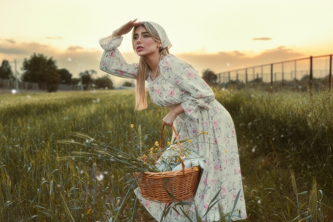 Woman in floral dress with basket looks into distance