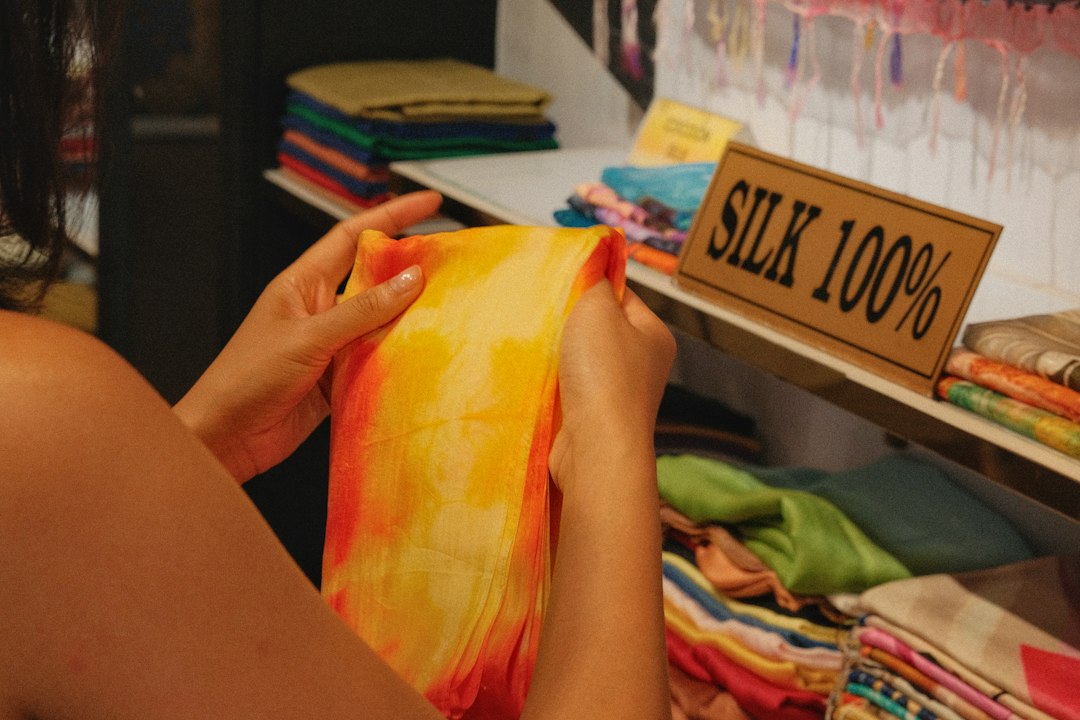 Woman examining colorful silk fabric in a store