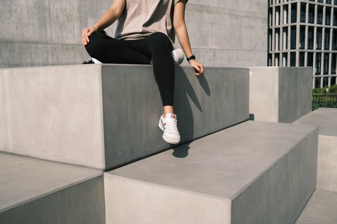a person jumping off a stone wall