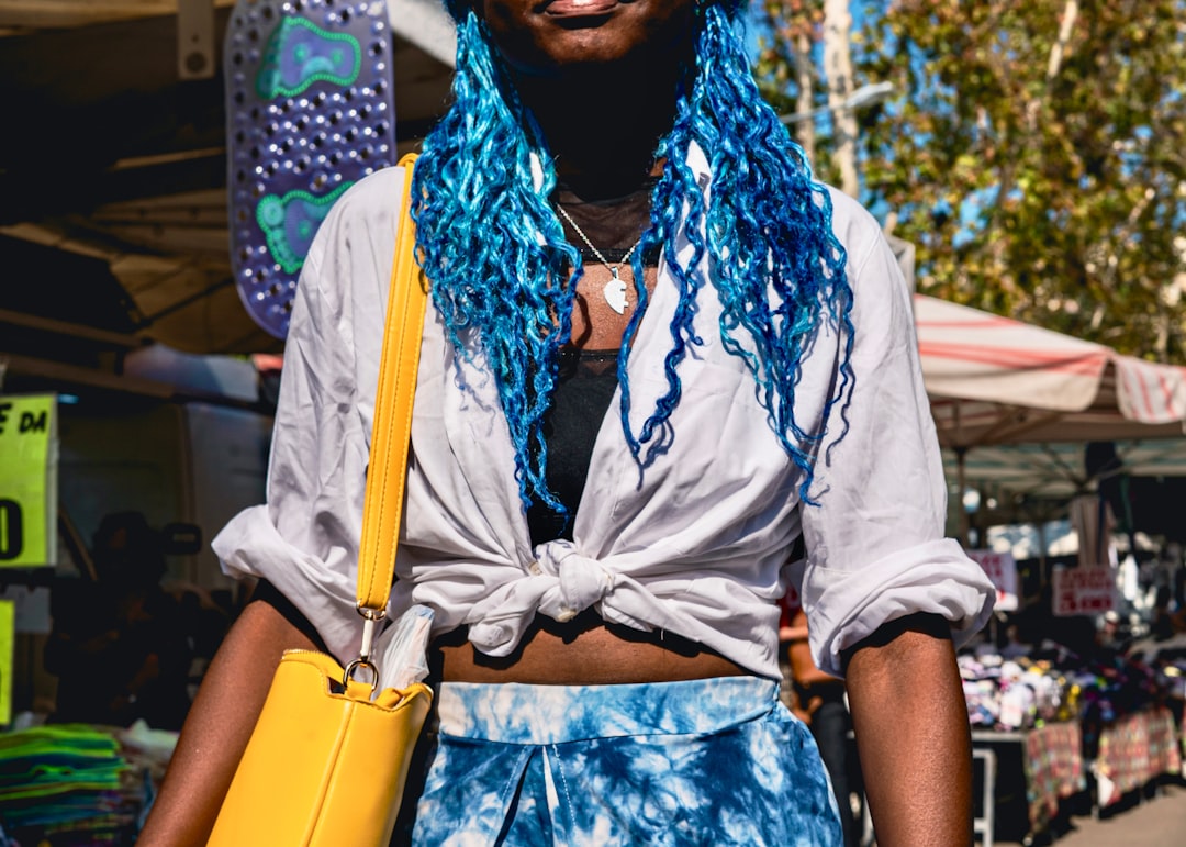 a woman with blue hair and a white shirt