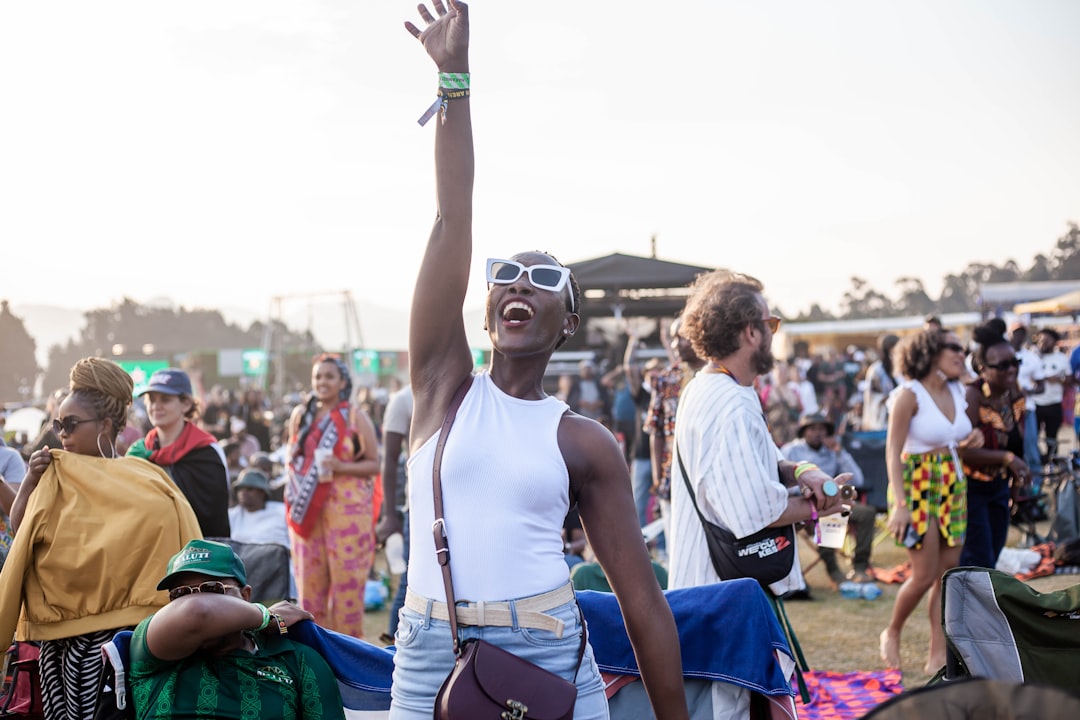 A man with his arms up in the air at a music festival