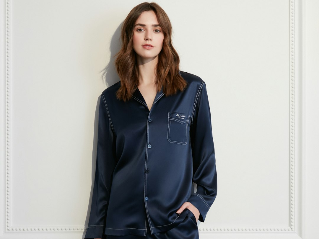 Woman wearing navy blue silk pajamas with white trim